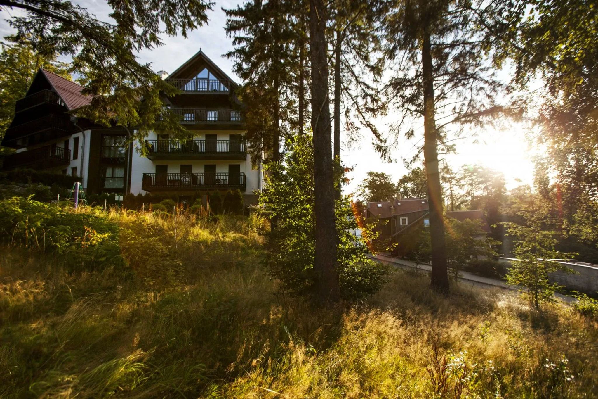 Budynki resortu wśród świerków o zachodzie